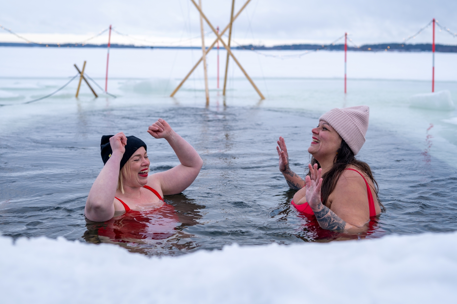 Foto på två kvinnor som badar i en isvak.